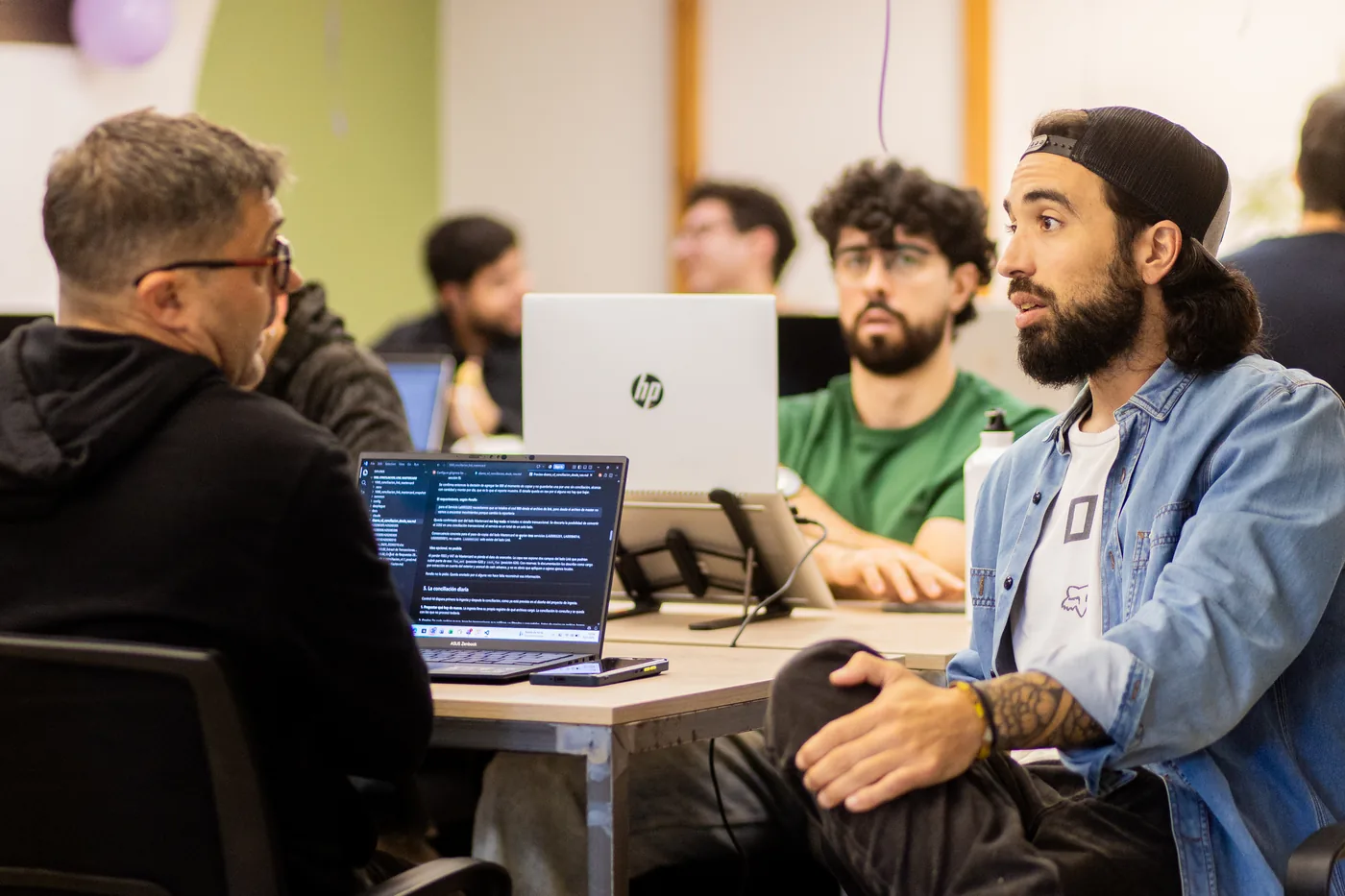 Part of the team in a technical working session, laptops showing code and documents